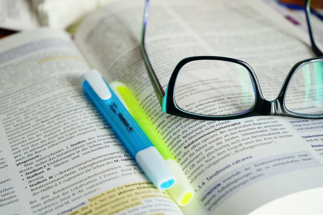 Buch mit Brille und Stift