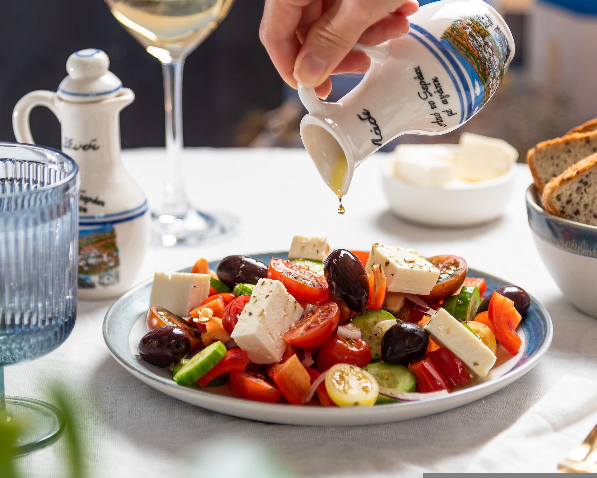 essenzielles_feta light im Test_Person leert Öl über griechischen Salat